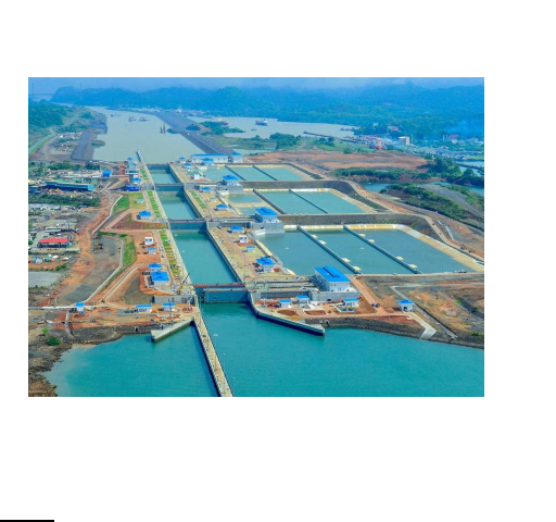 A imagem é uma vista aérea do Canal do Panamá, dando foco ao sistema de eclusas (parece um corredor com degraus longos) que eleva e desce os navios.
